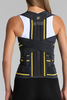 Person wearing a black and yellow back brace against a gray background